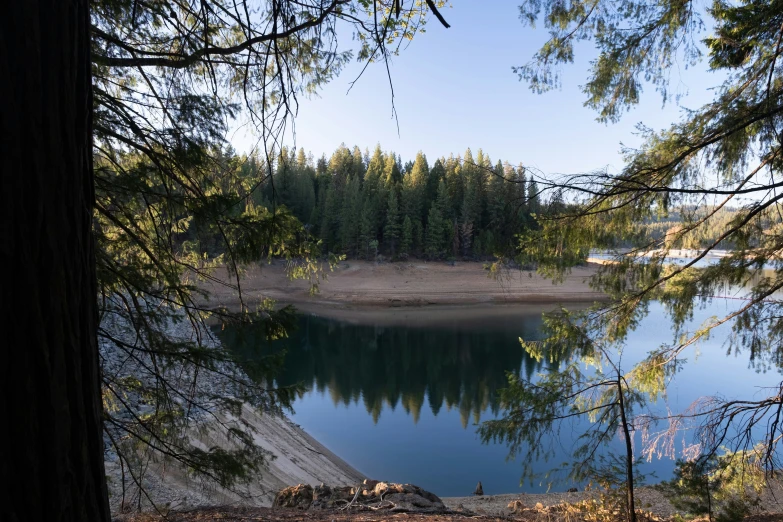 a lake is surrounded by trees on the shore