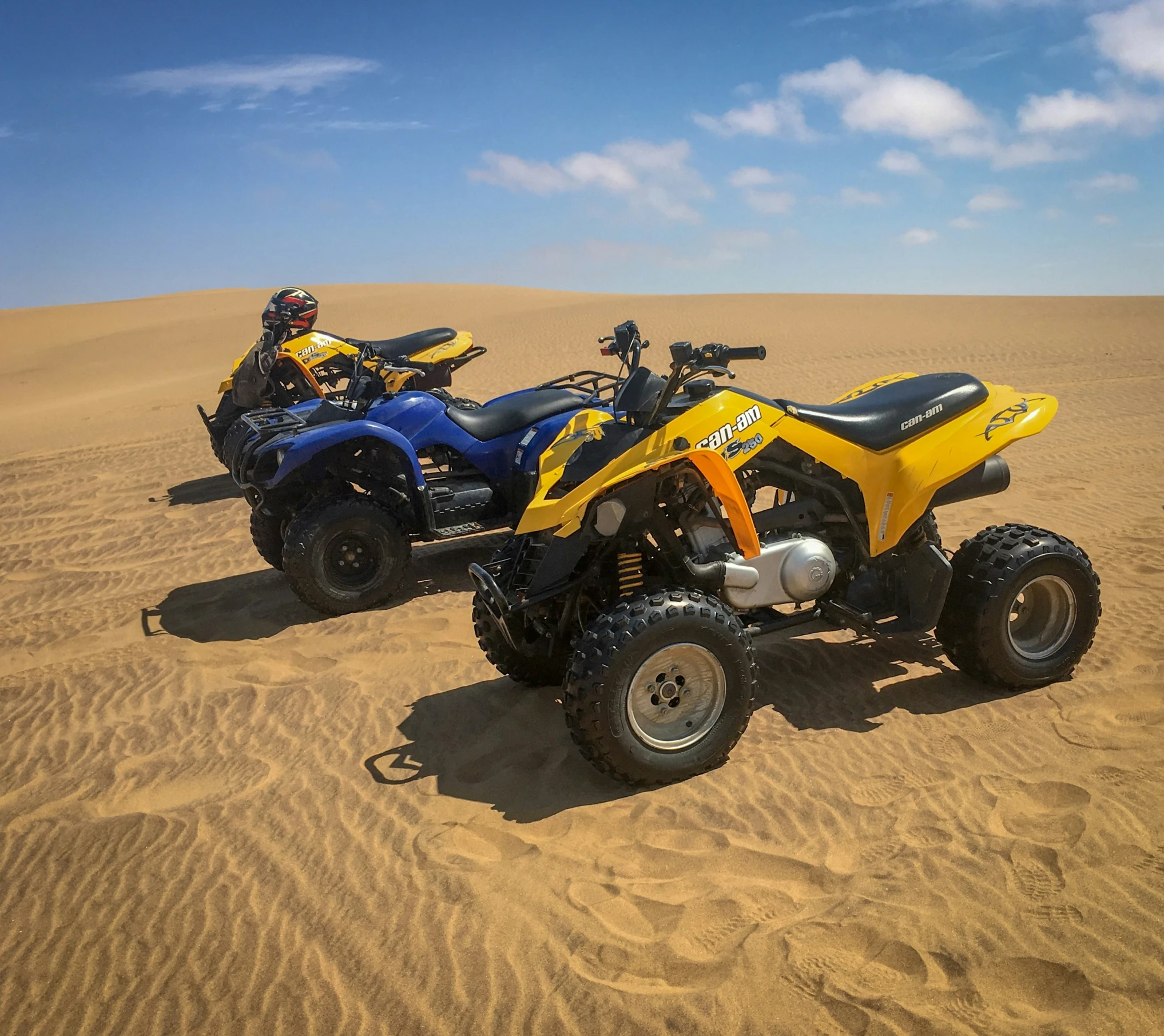 two people in quads are on a desert