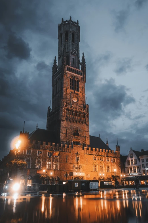 a tall building lit up at night with water in front