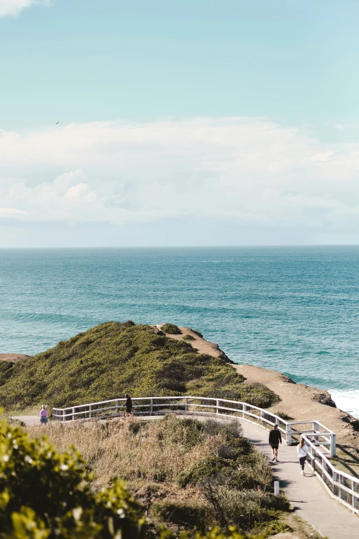 people stand on the path leading to the beach