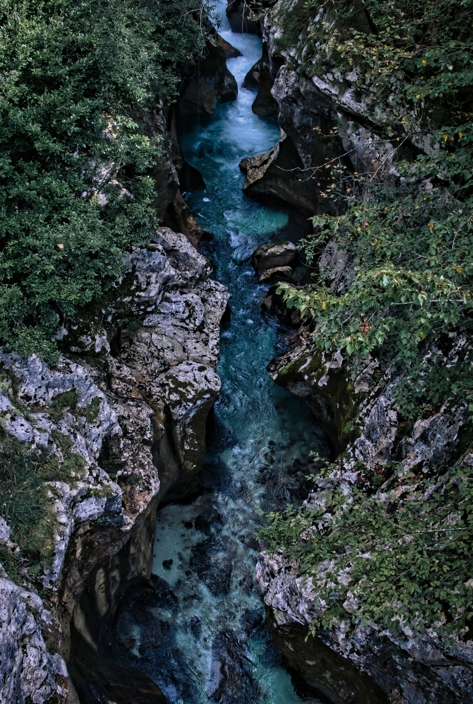 a river flowing between two large rocks next to forest