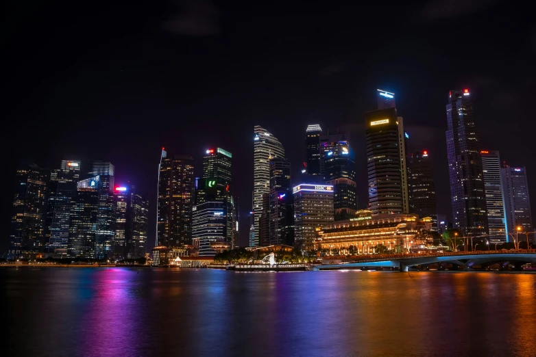 a big city skyline at night over some water