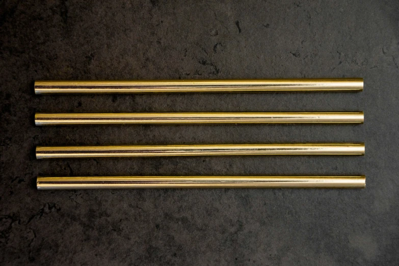four gold colored sticks laying on a table
