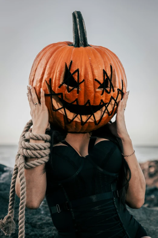 a woman holds a pumpkin with her head in her hands