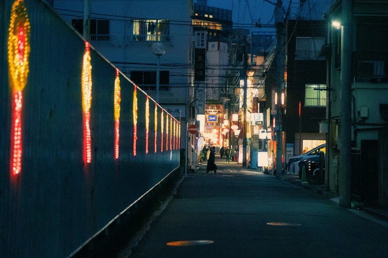a narrow alley lined with lights at night