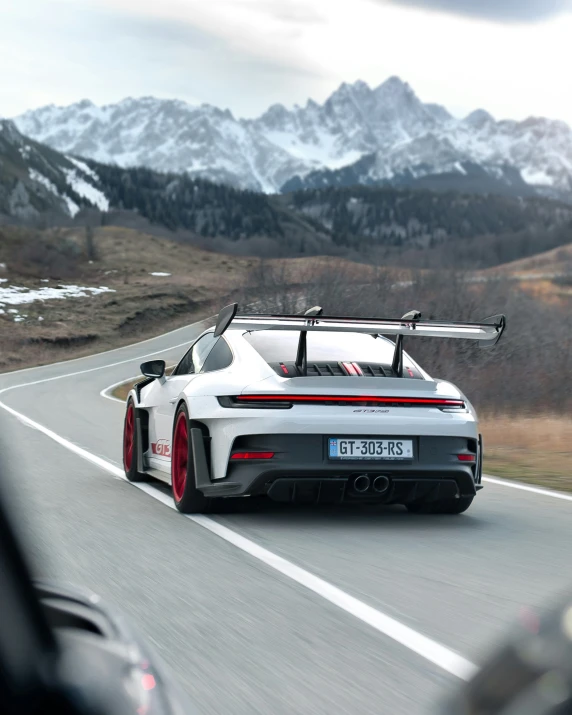 a white porsche sports car driving down the highway