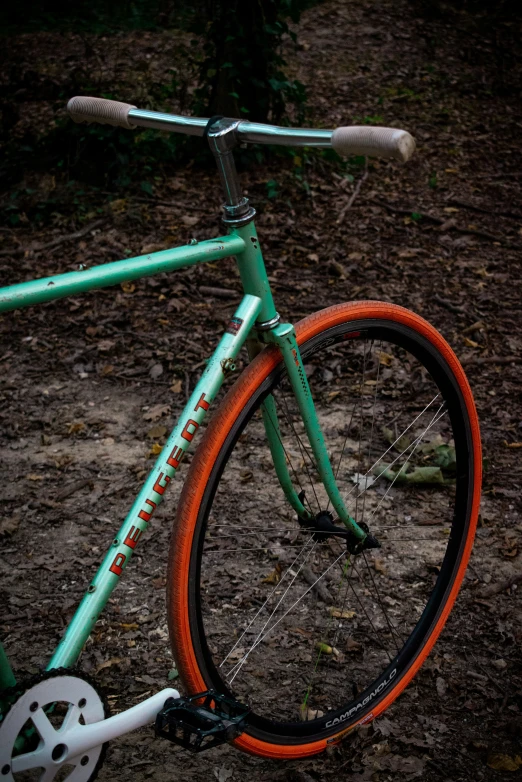 a closeup s of an orange, blue and green bicycle