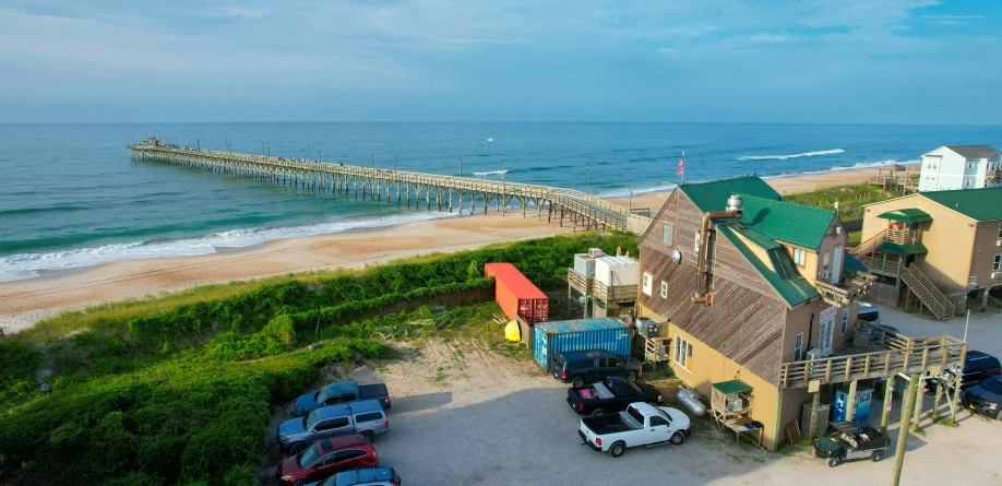 a parking lot with an old boathouse at the ocean shore