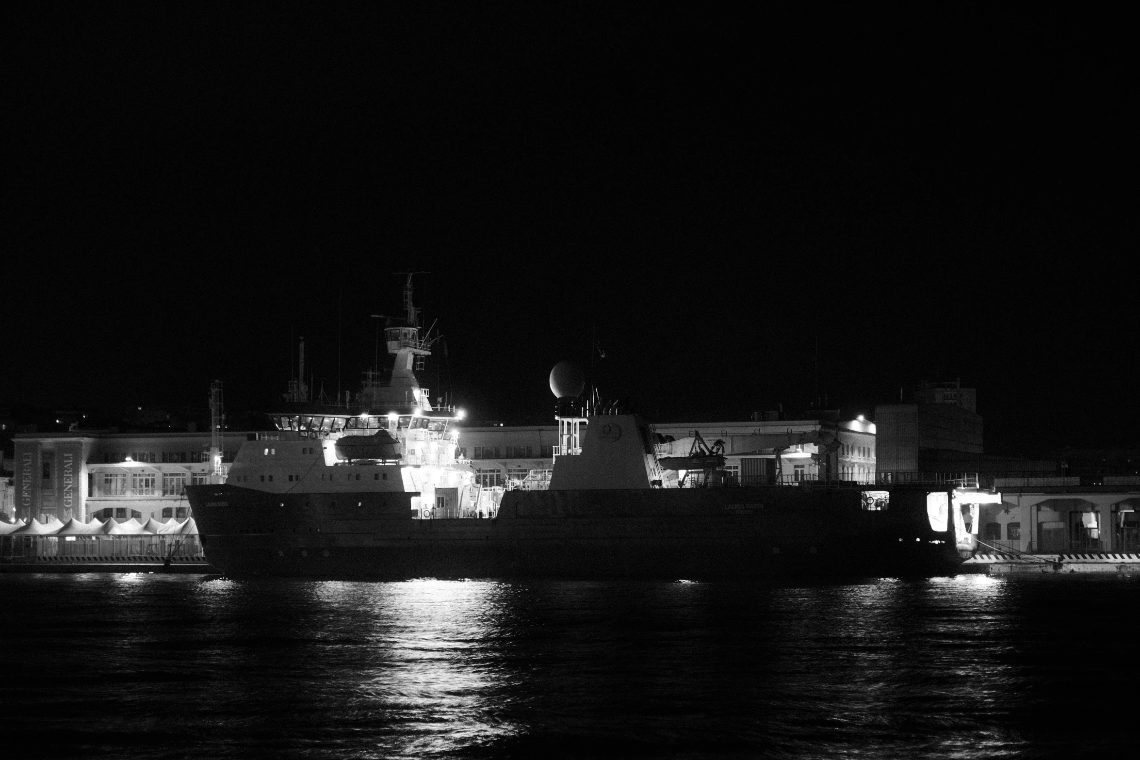 a ship is floating in the water with buildings in the background