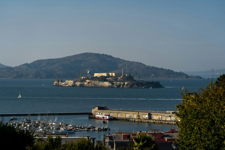 some boats docked on the water near a hill