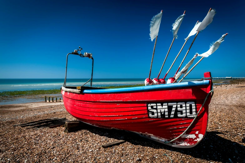 the boat is red with oars on the end