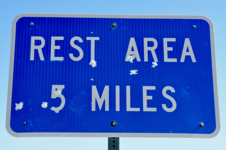 there is a road sign that says rest area 5 miles