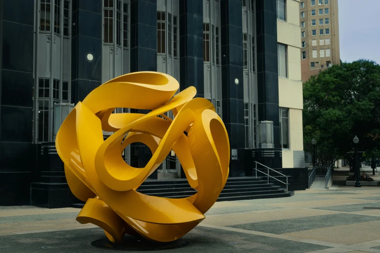 a large sculpture in a courtyard with many windows