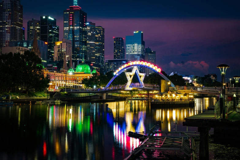 a large city is lit up at night and reflecting the lights