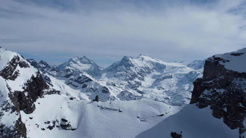 a man standing at the top of a mountain on a snowboard