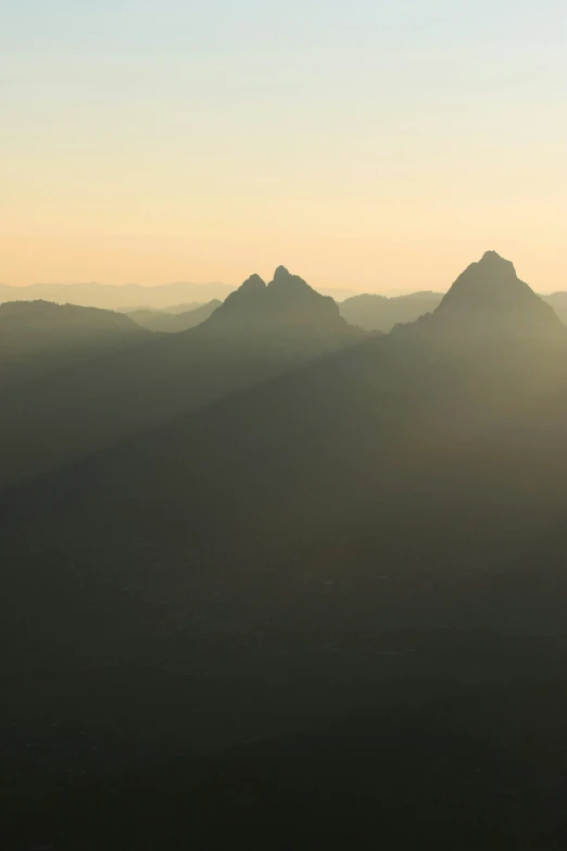 the sun is setting over mountains in the distance