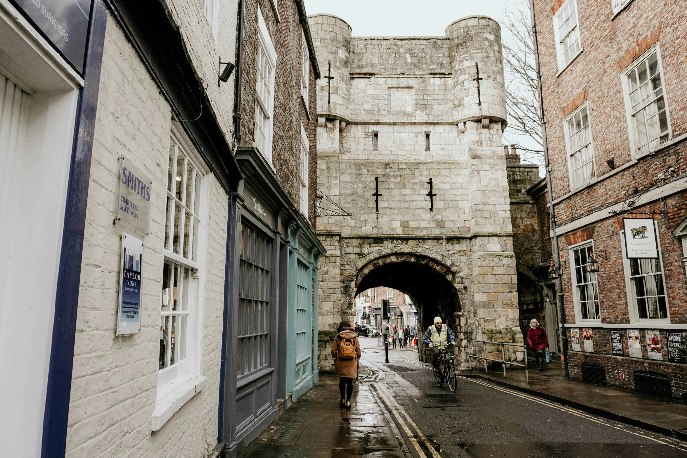 a couple of people walking down a street in the rain