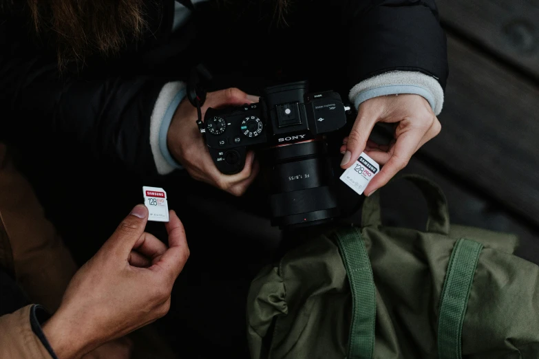 two people hold up their cameras and look at them