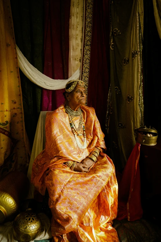 a person sitting in an orange sari