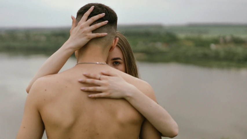 a man that has his hand over the face of a woman who is hugging her forehead