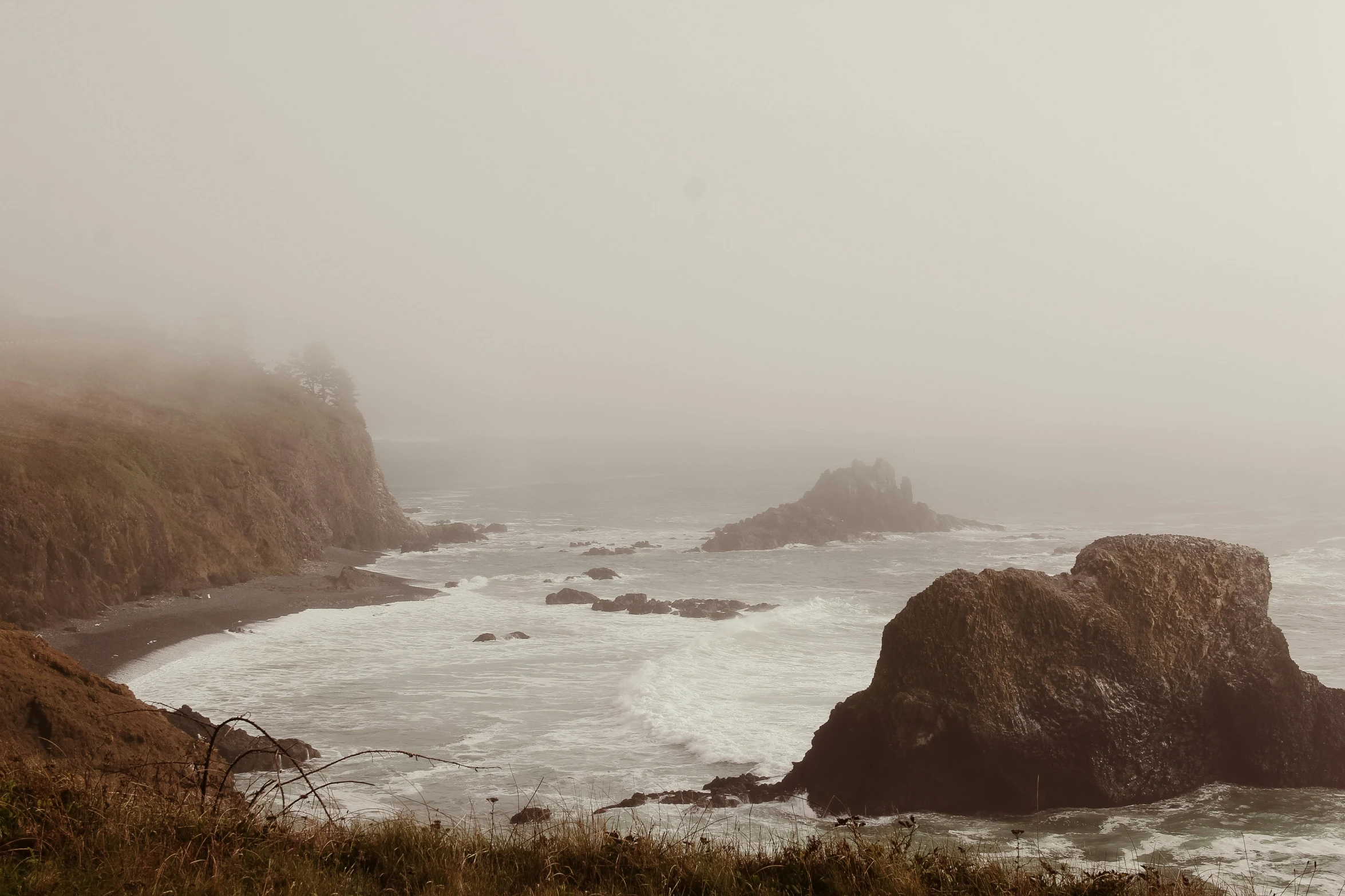 the shoreline is full of waves and fog