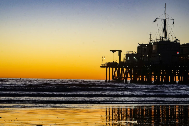 a wooden pier with water waves and birds flying in the air