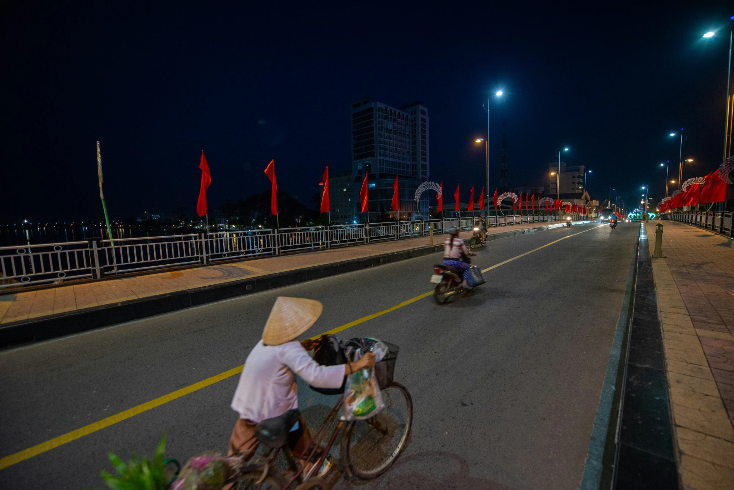 people are riding bicycles on the street at night