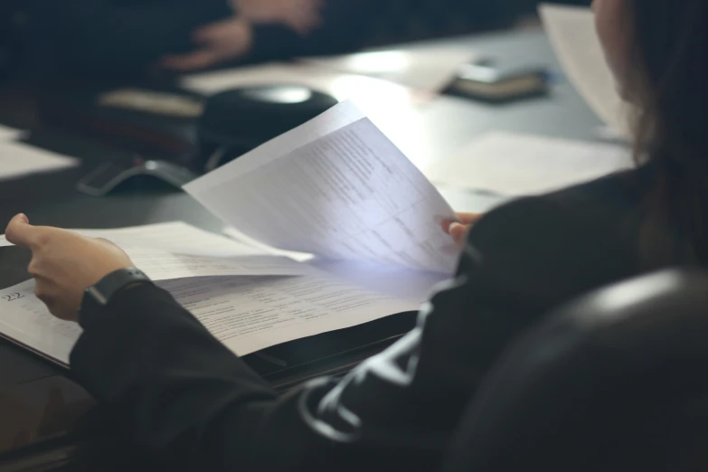 a woman with her hands on the paper at her desk