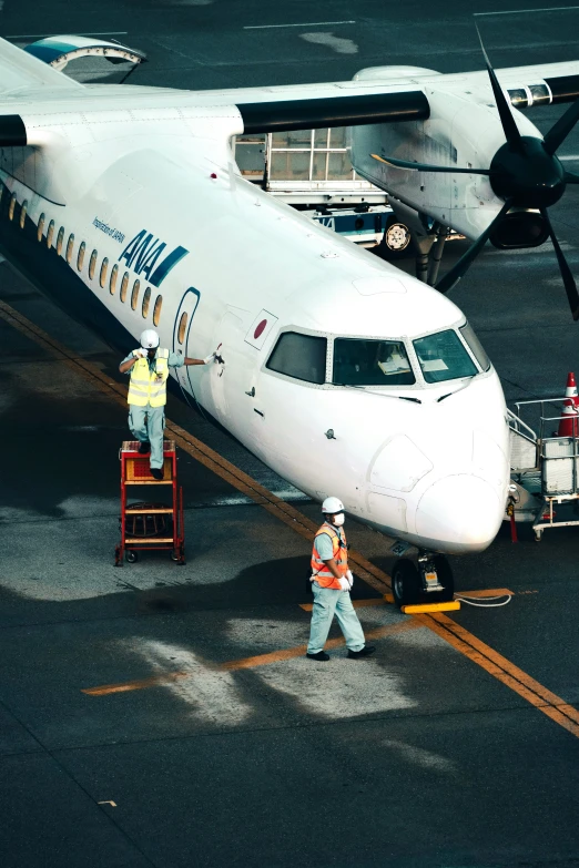 a man is walking towards an airplane that is being serviced