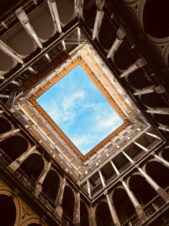 a square, ornately shaped, building with a blue sky in it