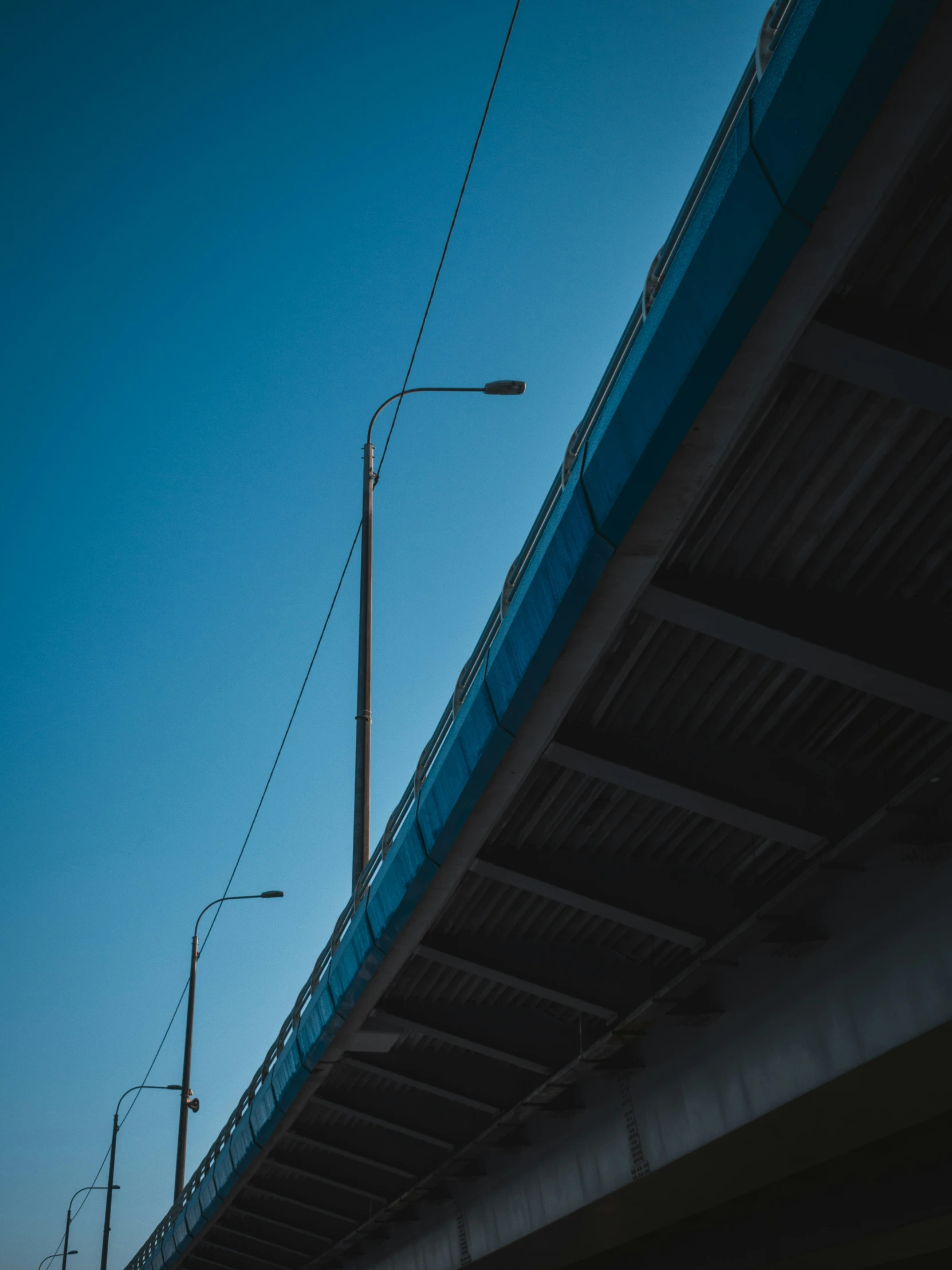 the view of a bridge at sunset with traffic signals and street lights