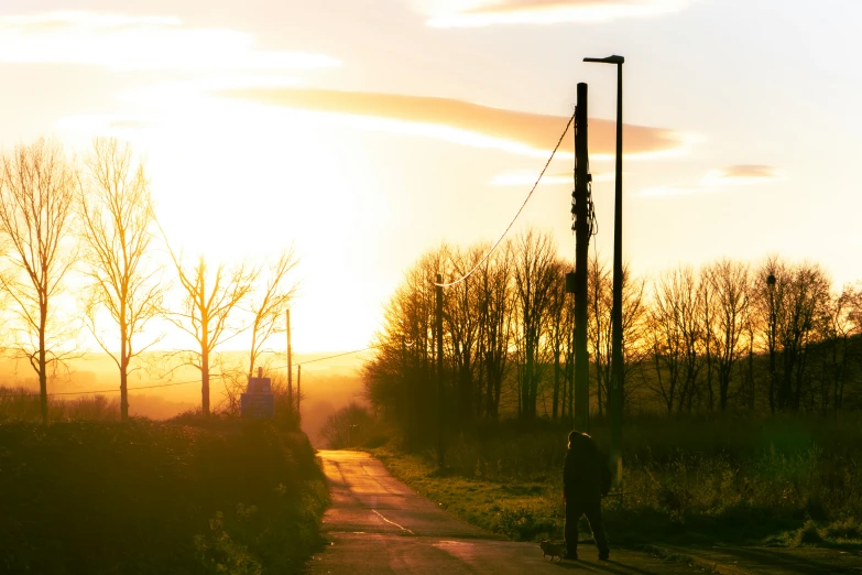 a single woman walks down the side of a rural road