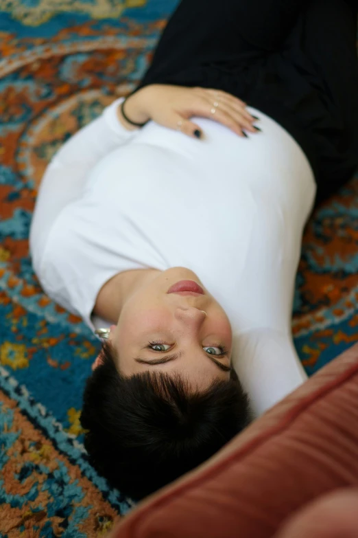 a woman with black hair and eyes laying on the ground
