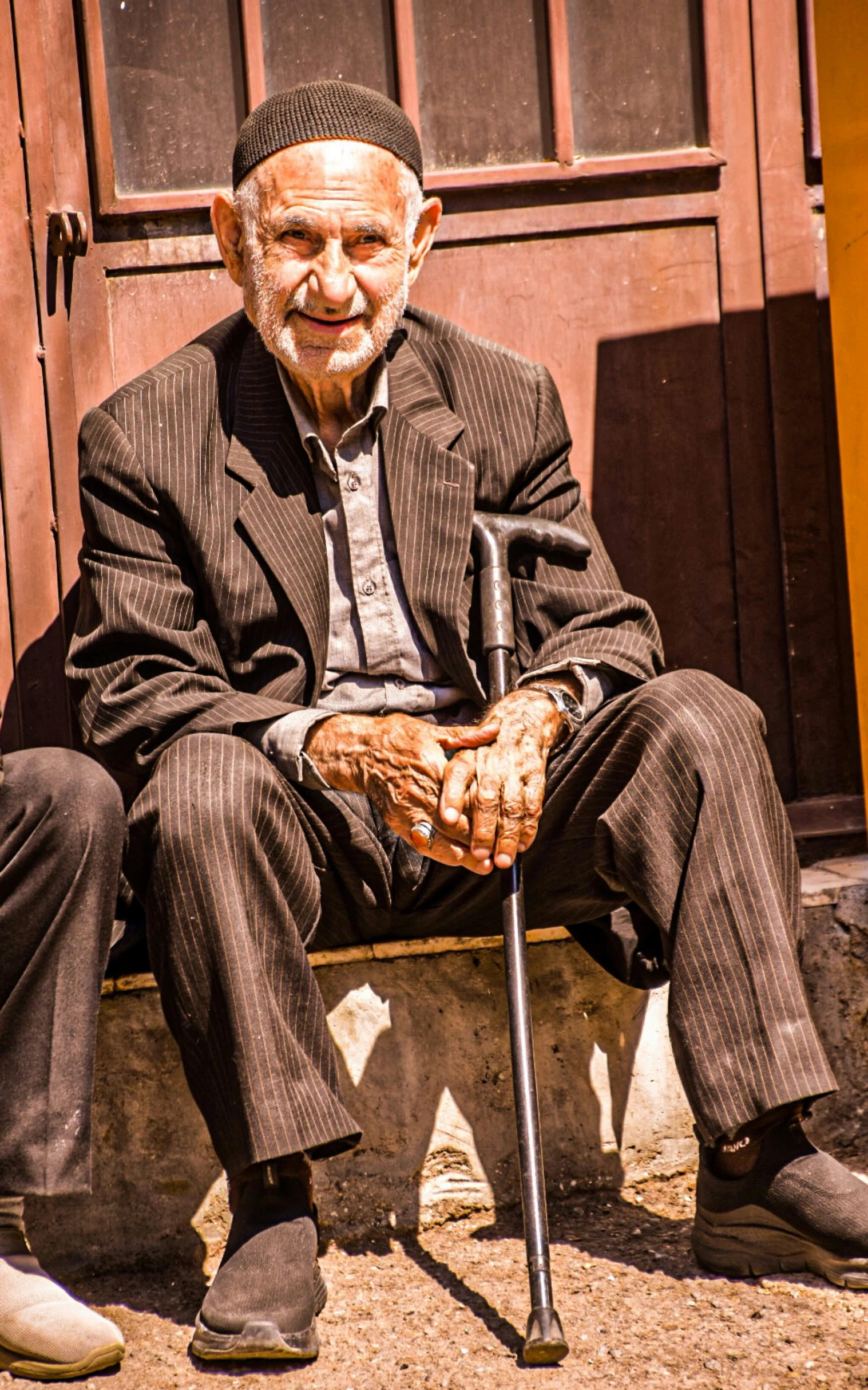 an older man sitting on a park bench outside