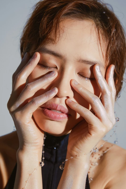 a woman with her eyes closed with wet hands