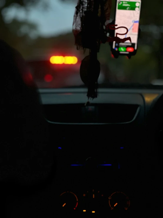 a car dashboard with an electronic device hanging from it