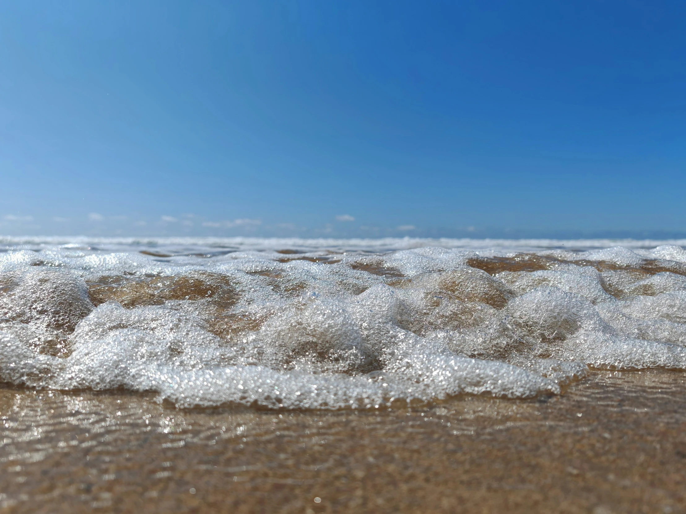 a view of water and sand with blue skies