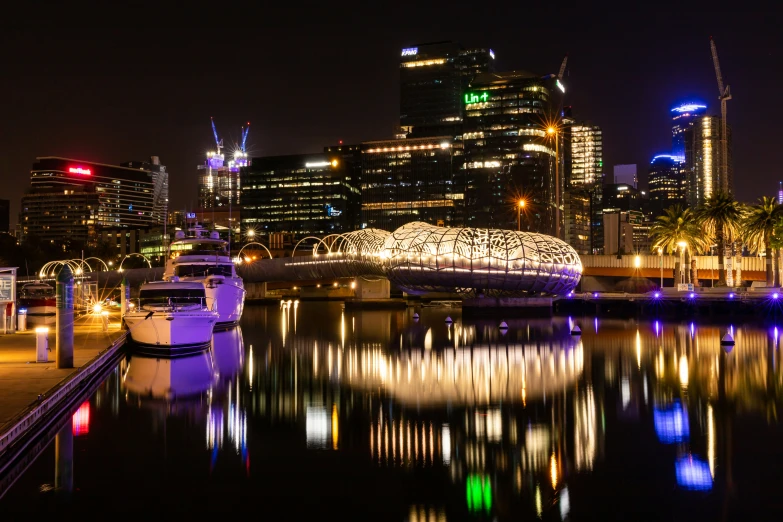 many large buildings and lights next to the water