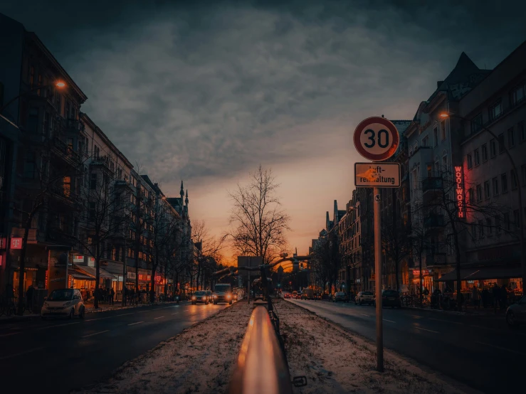 street signs on snow covered pavement during evening