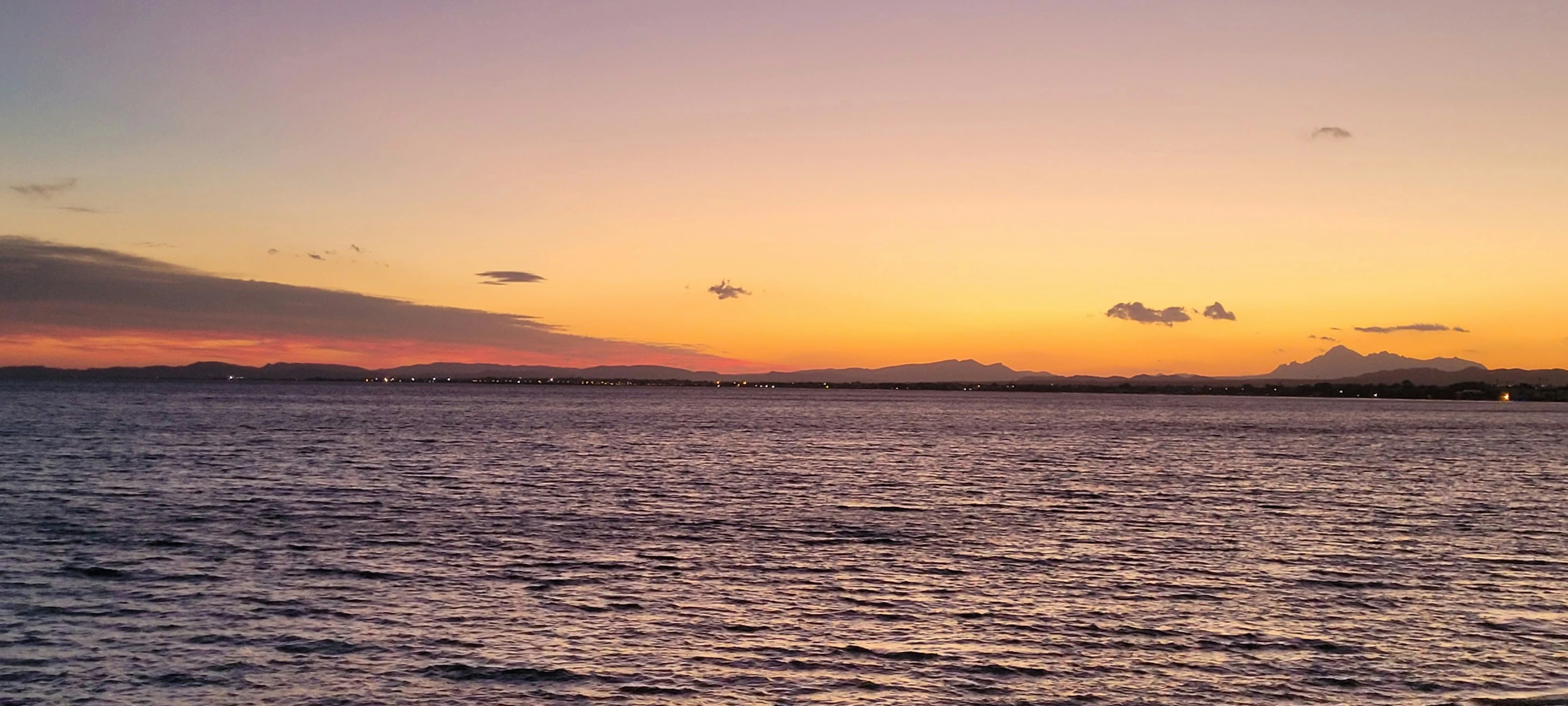 a large body of water sitting under a bright sky