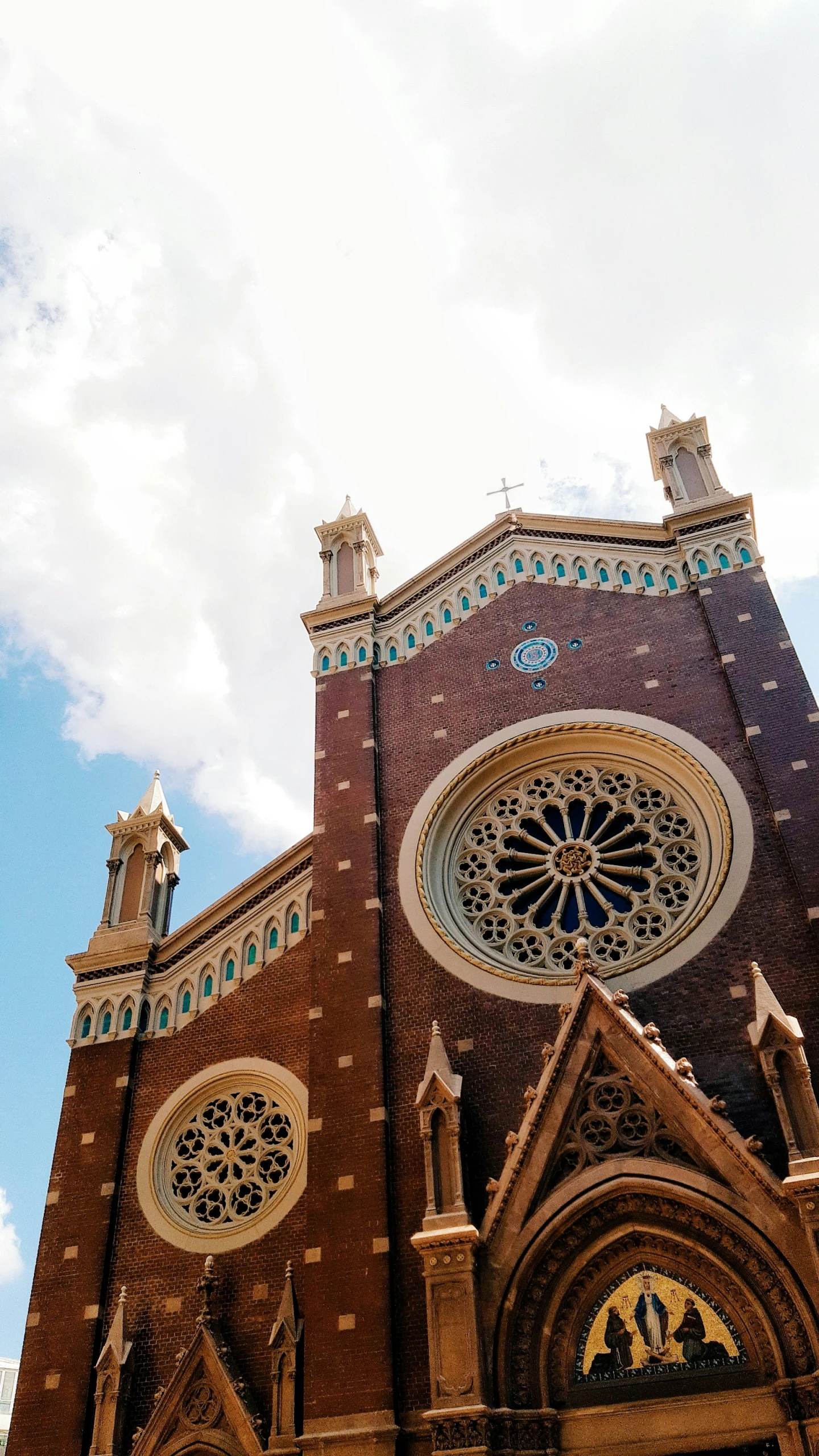 a large brown and tan church with a tall clock tower