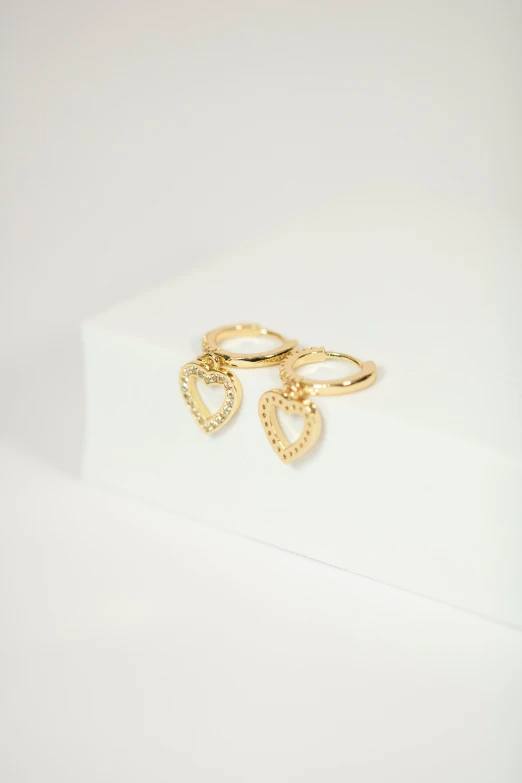 a couple of gold rings sitting on top of a white table