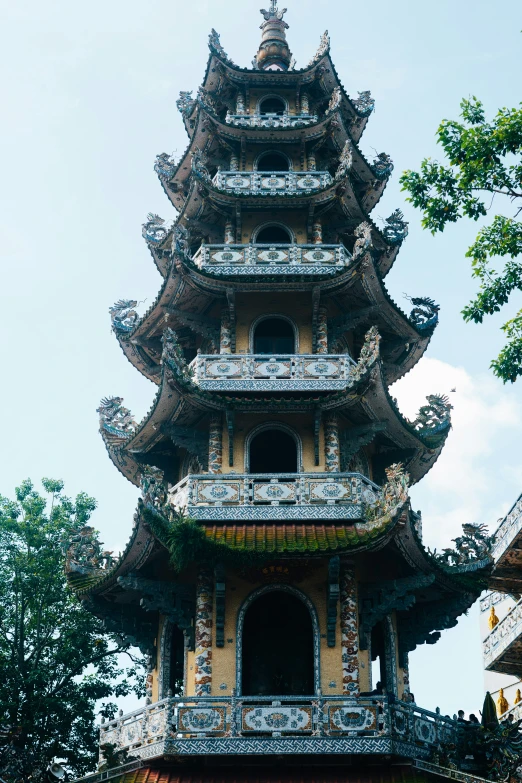 an ornate pagoda on a cloudy day near trees