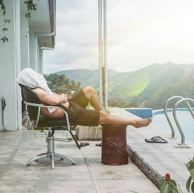 man relaxing by the pool while taking a break