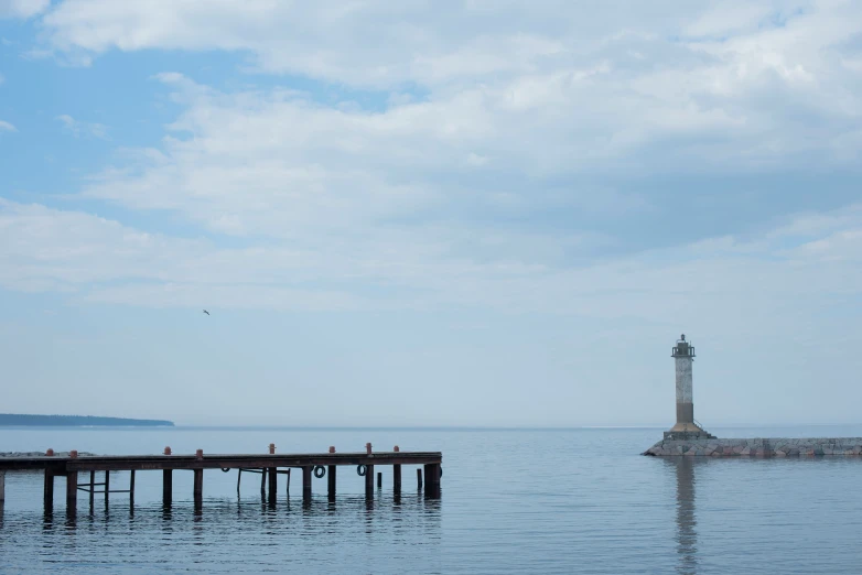 a light house is in the middle of a body of water