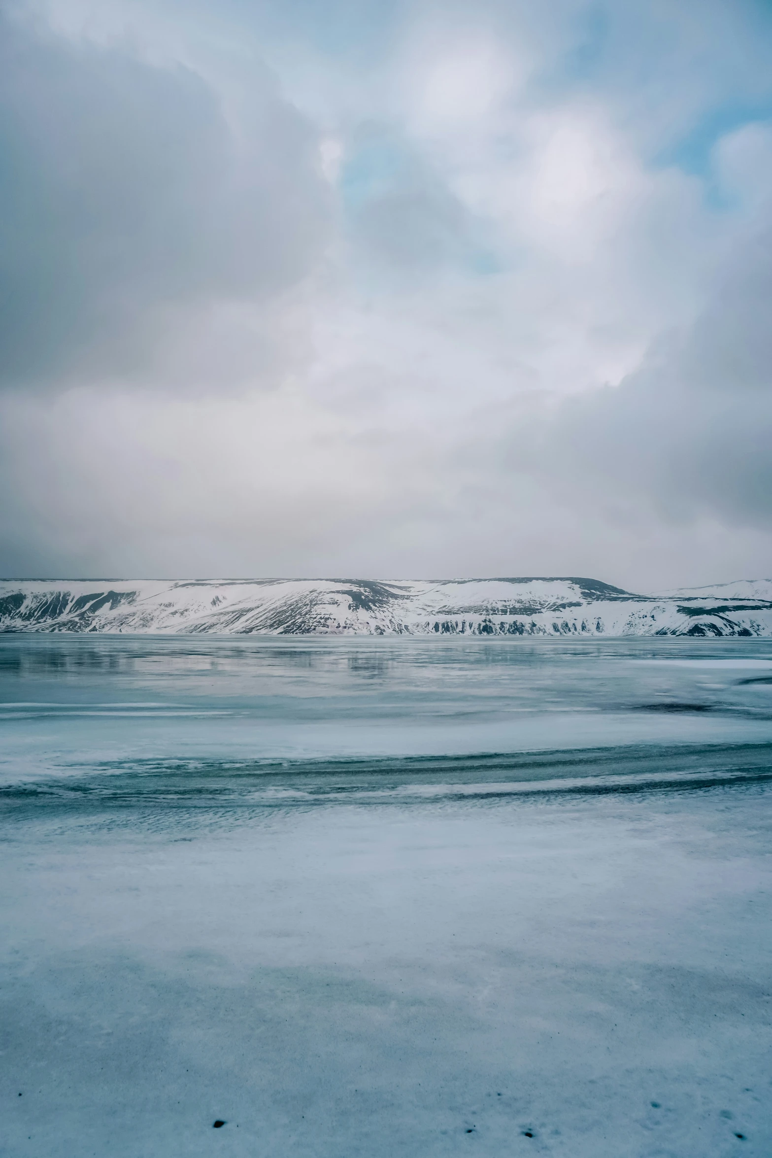 a sky view of snow covered hills and water