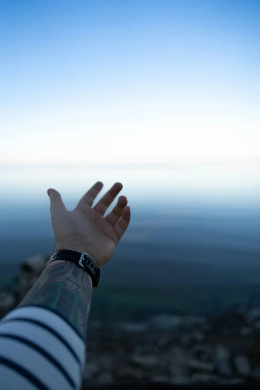 someone with their hand up high above the water