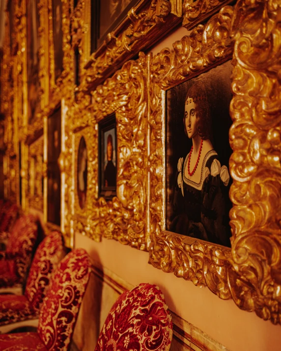 the gold frame has paintings hanging on it