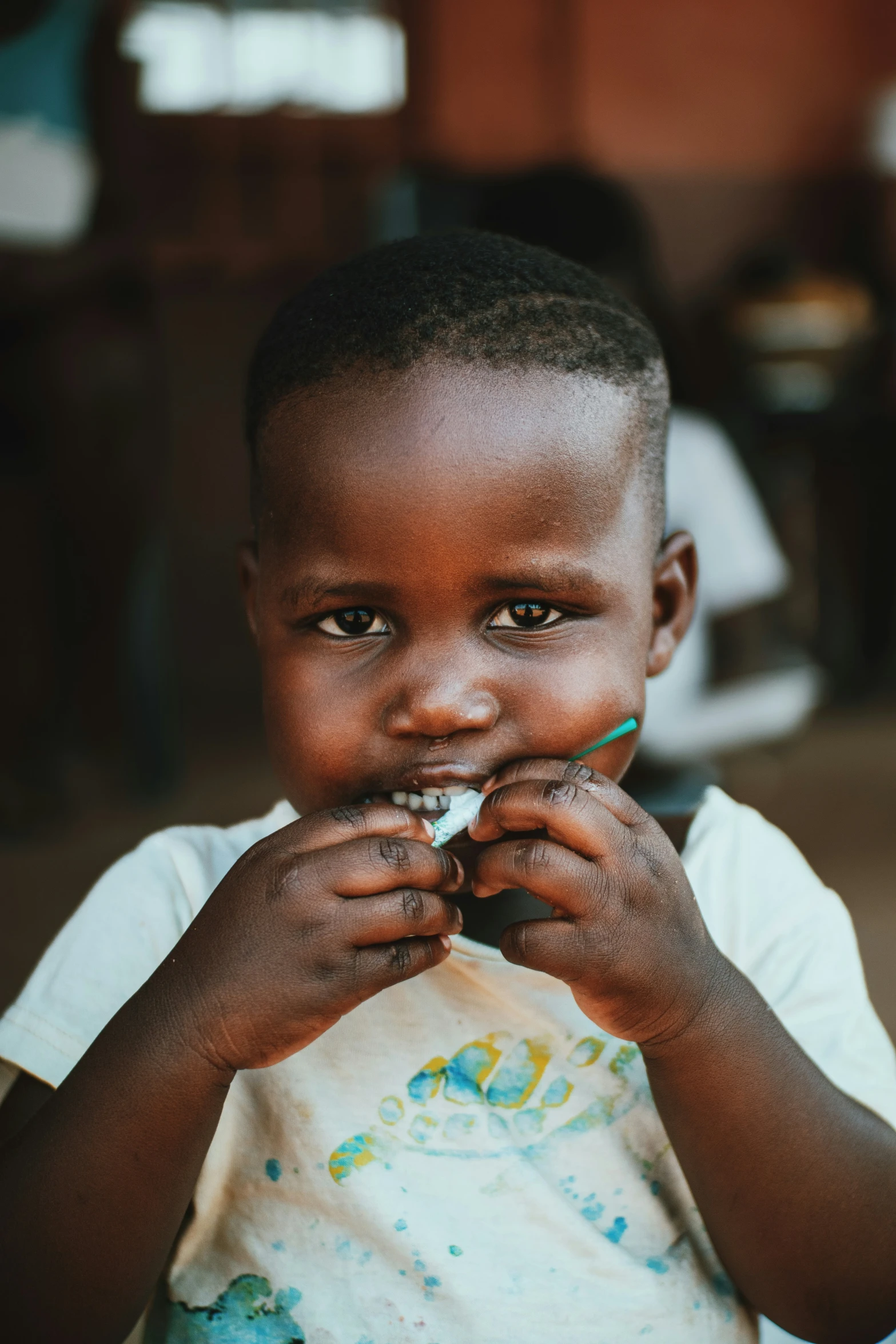 a little boy sitting in front of the camera eating food