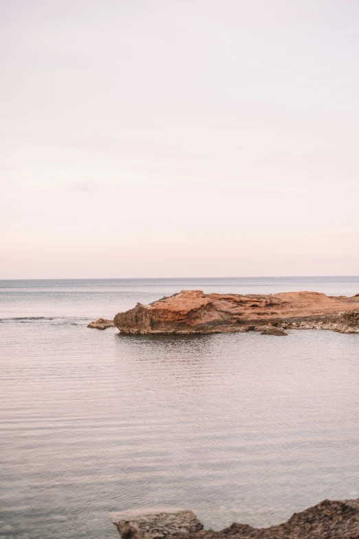 a lone boat near an island in the middle of the ocean